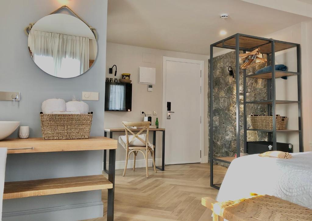 a bedroom with a bed and a mirror and a table at Hotel Abaco Altea in Altea