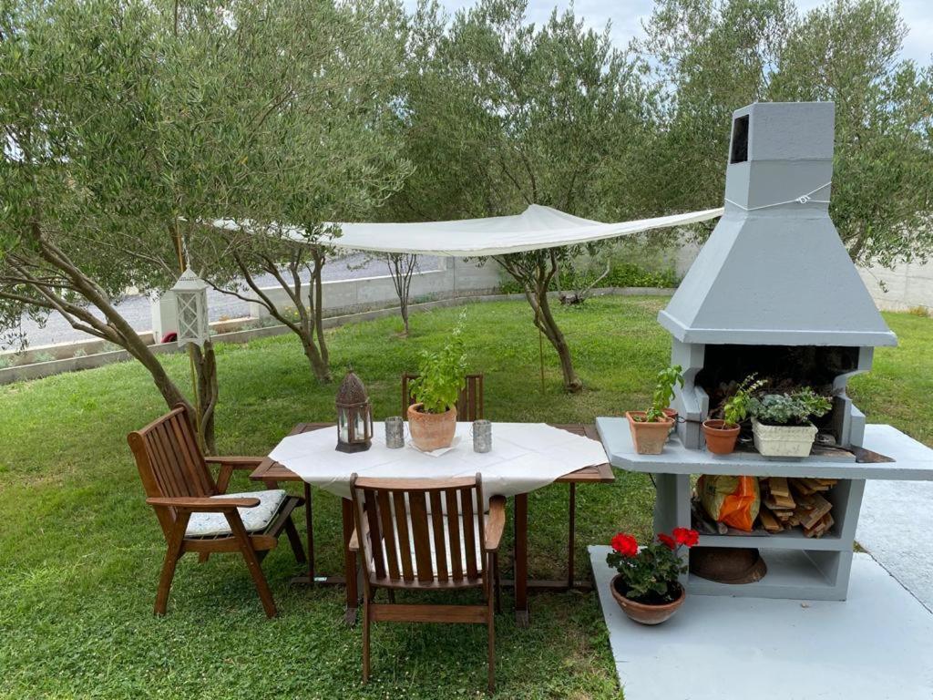 a table and chairs with a grill in a yard at Casa Fumica Apartment in Palit