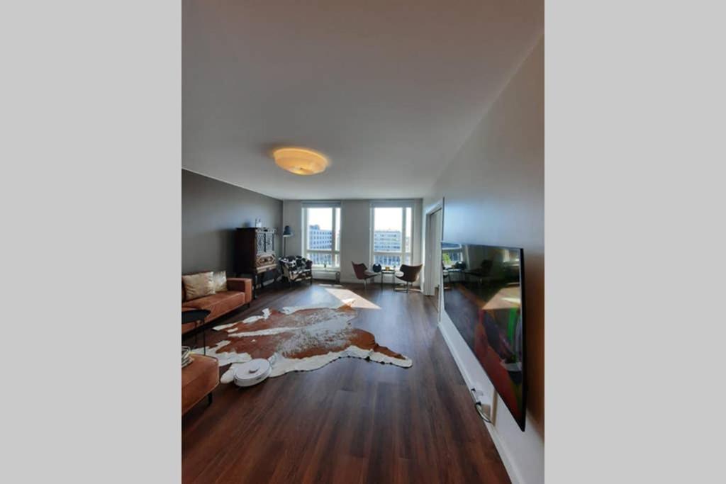 uma sala de estar com pisos em madeira e paredes brancas em 90m2 on pedestrian street on Top Floor, penthouse suite, great view! Incl linen and all em Pori
