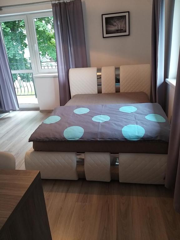 a bedroom with a bed with blue pillows on it at Marysieńka in Krynica Morska