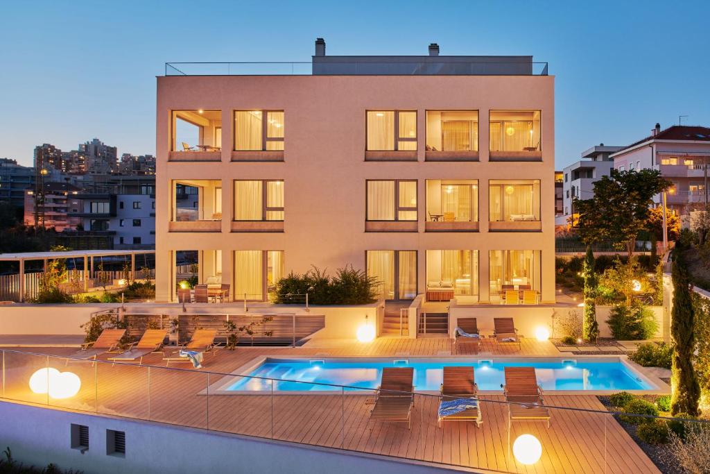 a building with a swimming pool in front of it at Eol Apartments Split in Split