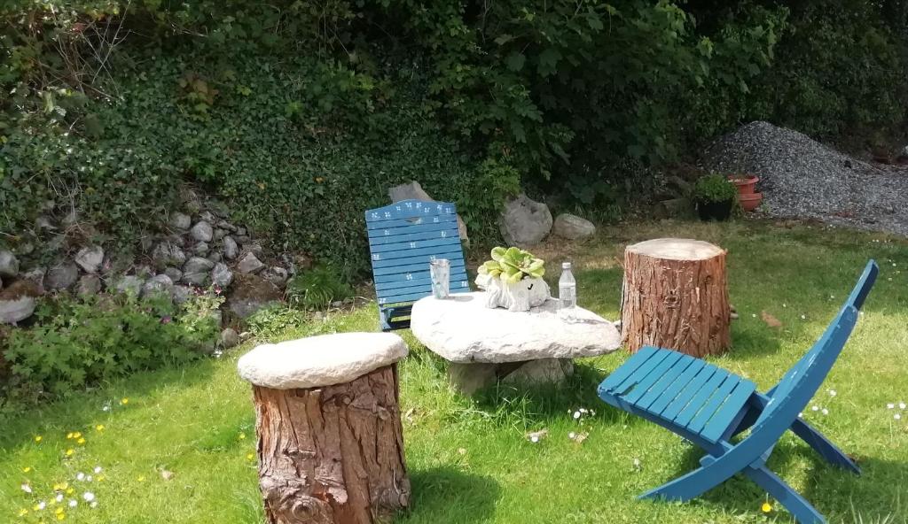 a garden with a bench and a blue chair at The Loft in Foxford in Foxford