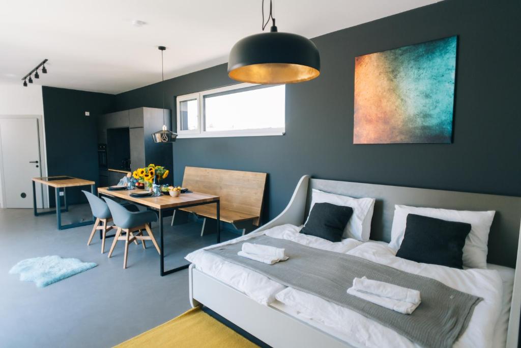 a bedroom with a bed and a dining room at Wave Penthouses in Neusiedl am See