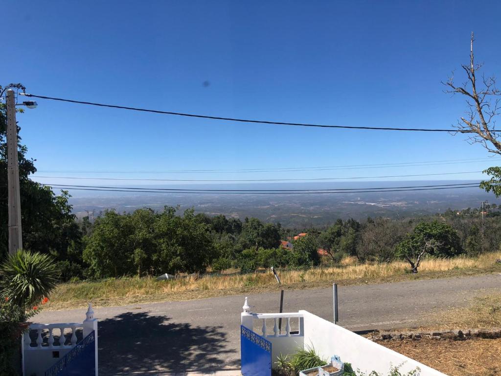 uma vista para uma estrada a partir de uma colina com um céu azul em VIVENDA AZUL em Monchique
