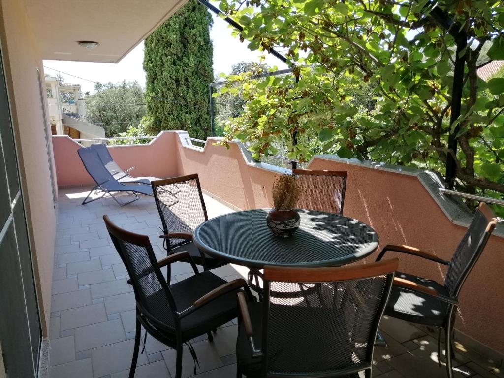 patio con mesa y sillas en el balcón en Apartman 2 Punta Pakoštane en Pakoštane