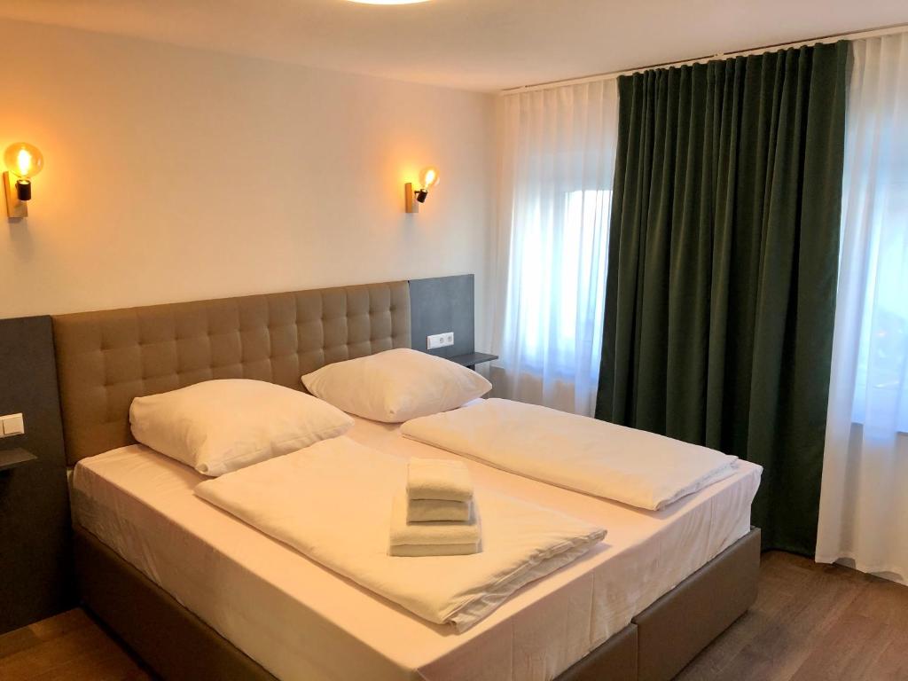 a bedroom with a large bed with a green curtain at City Apartments in Metzingen