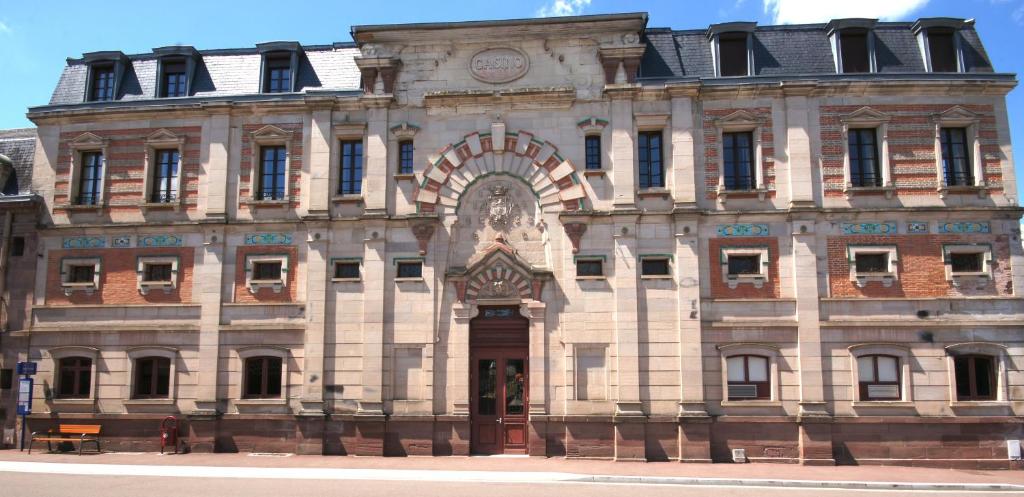 een oud gebouw met een klok erop bij F2 Aux pieds des Thermes 3 étoiles in Luxeuil-les-Bains