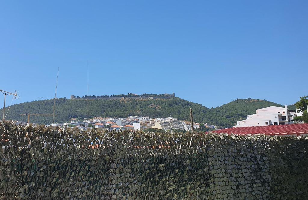a stone fence with a city in the background at Vila Azul in Sesimbra