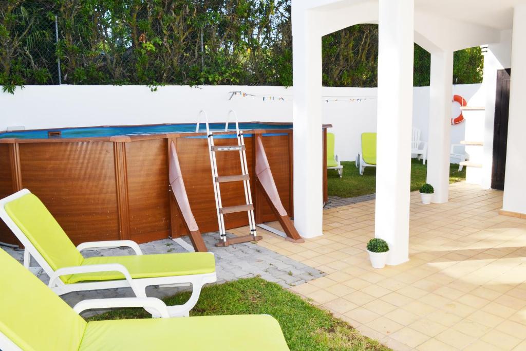 a patio with chairs and a swimming pool at Vivenda Vau in Portimão