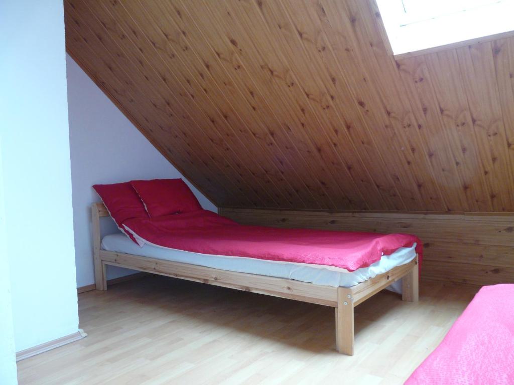 Łóżko w pokoju z drewnianym sufitem w obiekcie Mi-Ri Balance vendégház w mieście Szinpetri