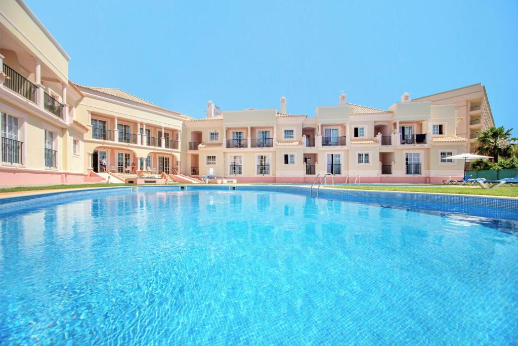 a large swimming pool in front of a building at Aquamar Albufeira Aparthotel in Albufeira