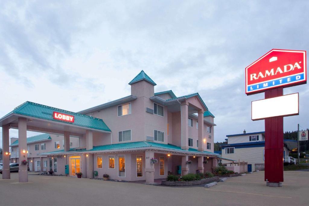 a hotel with a sign in front of it at Ramada Limited 100 Mile House in One Hundred Mile House