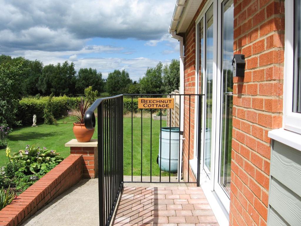 a gate with a sign that reads backyard surprise at Beechnut Cottage in Tewkesbury