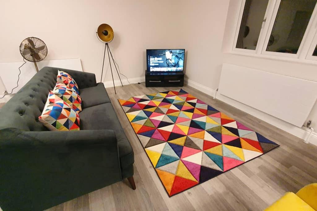 sala de estar con sofá y alfombra colorida en Garland Modern Spacious Apartment, Brentwood 2, en Brentwood