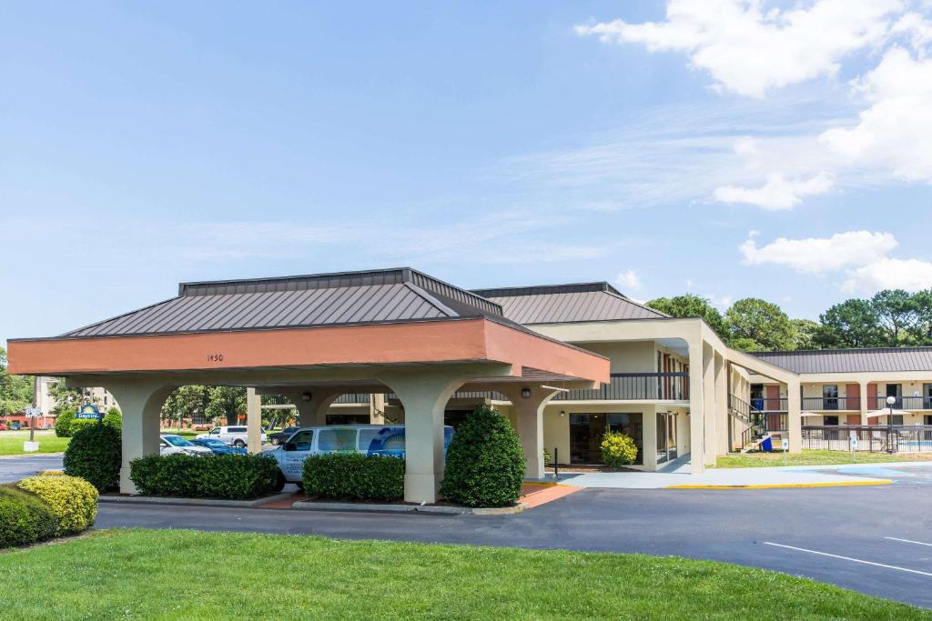 um hotel com carros estacionados em frente a um parque de estacionamento em Days Inn by Wyndham Norfolk Airport em Norfolk