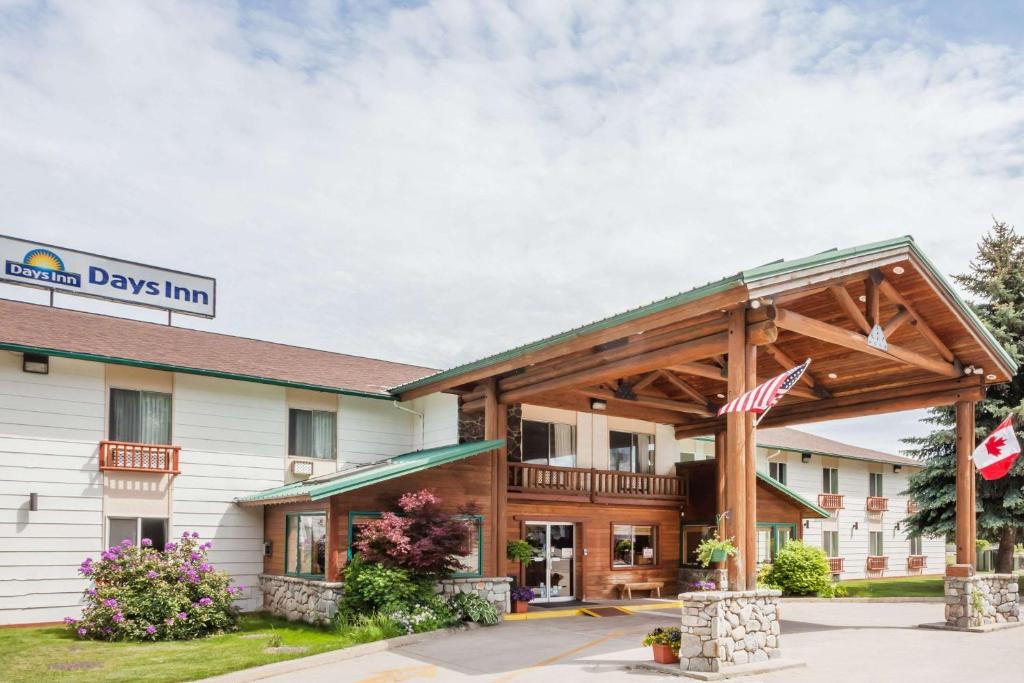 uma vista frontal de um hotel com uma bandeira americana em Days Inn by Wyndham Sandpoint em Ponderay