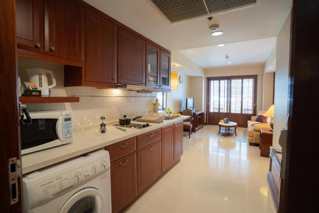 A long suite kitchen with a washing machine opening toward the living room.