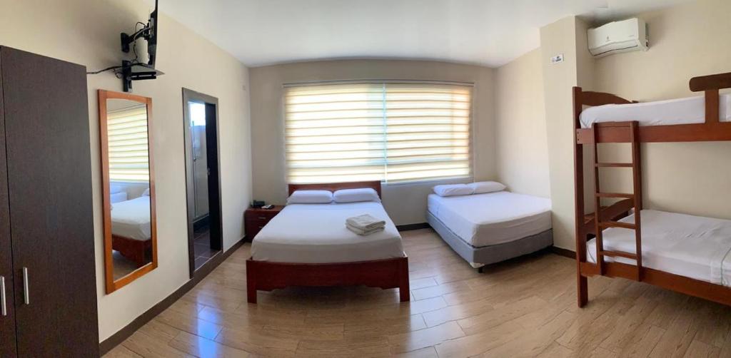 a bedroom with two bunk beds and a mirror at Hotel Arena Blanca in Salinas
