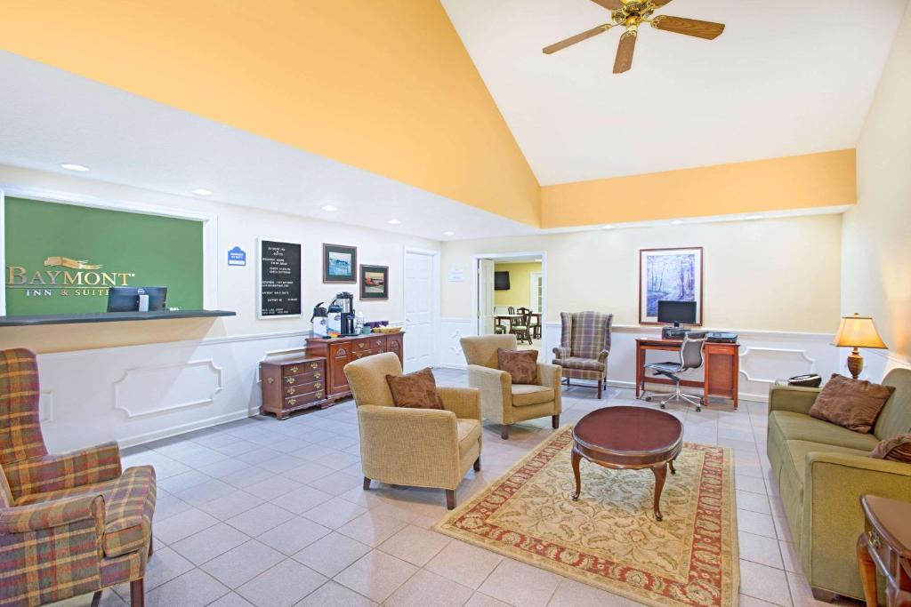 a lobby with a waiting room with couches and chairs at Baymont by Wyndham Forest City in Forest City