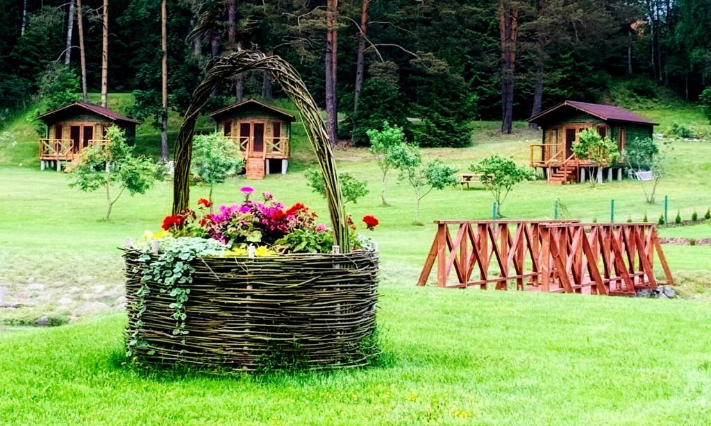 una cesta de flores en el césped con casas en el fondo en Orupõhja kämpingud ja telkimisala en Põlva