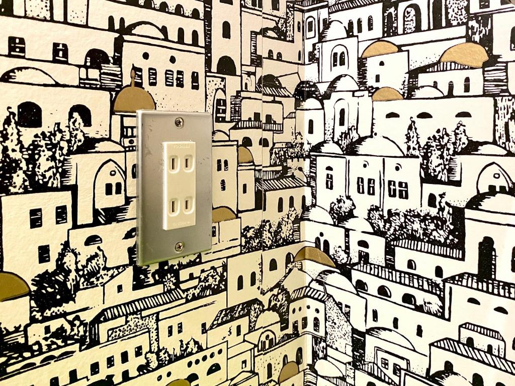 a wall with a drawing of a city at Guest House MARUYA in Atami