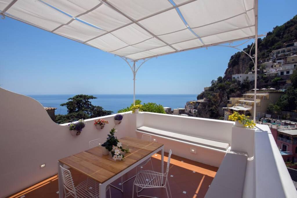 balcón con mesa y vistas al océano en CASA BAKER luxury apartment, en Positano