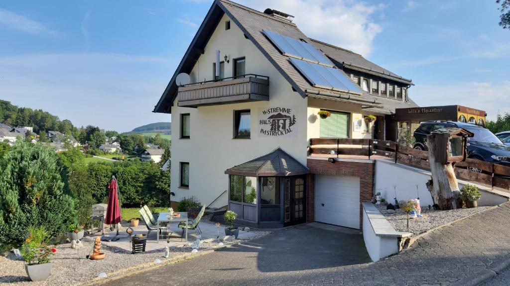 uma grande casa branca com garagem em Haus im Strycktal em Willingen