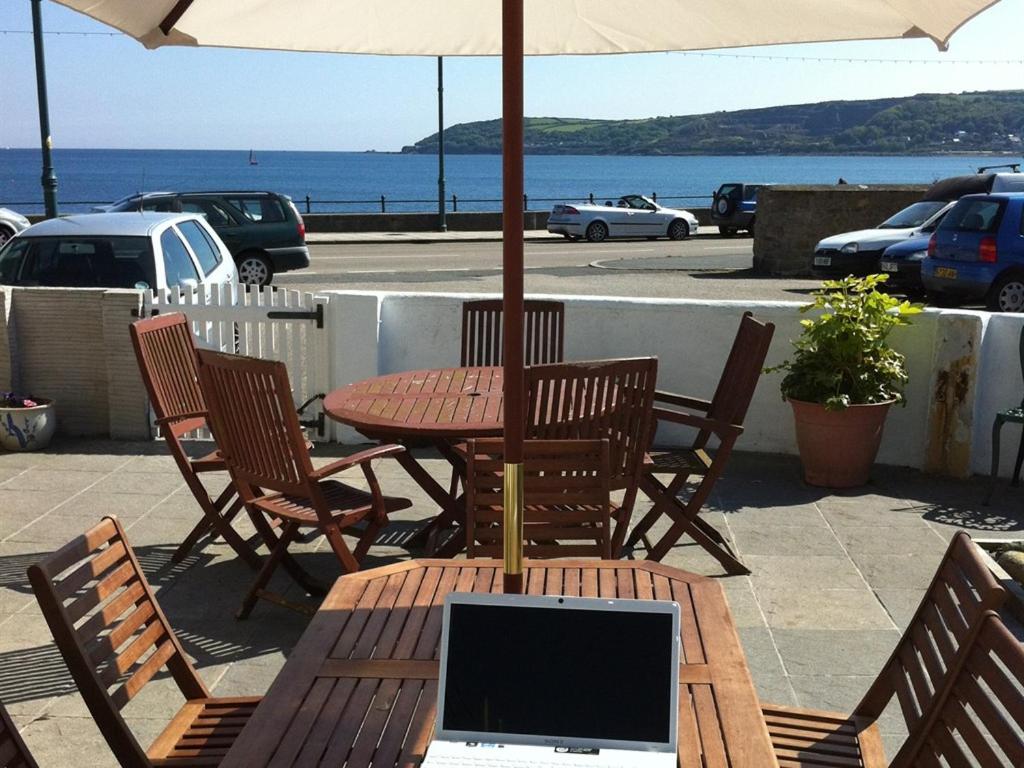 a table and chairs with an umbrella and a laptop on it at The Stanley in Penzance