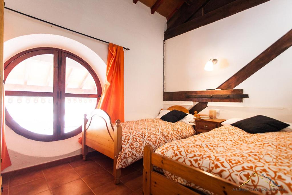 una camera da letto con due letti e una grande finestra di Albergue de Espiel a Espiel