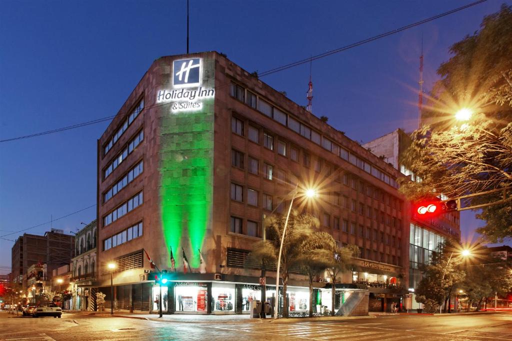 um edifício com luz verde na lateral em Holiday Inn Hotel & Suites Centro Historico, an IHG Hotel em Guadalajara