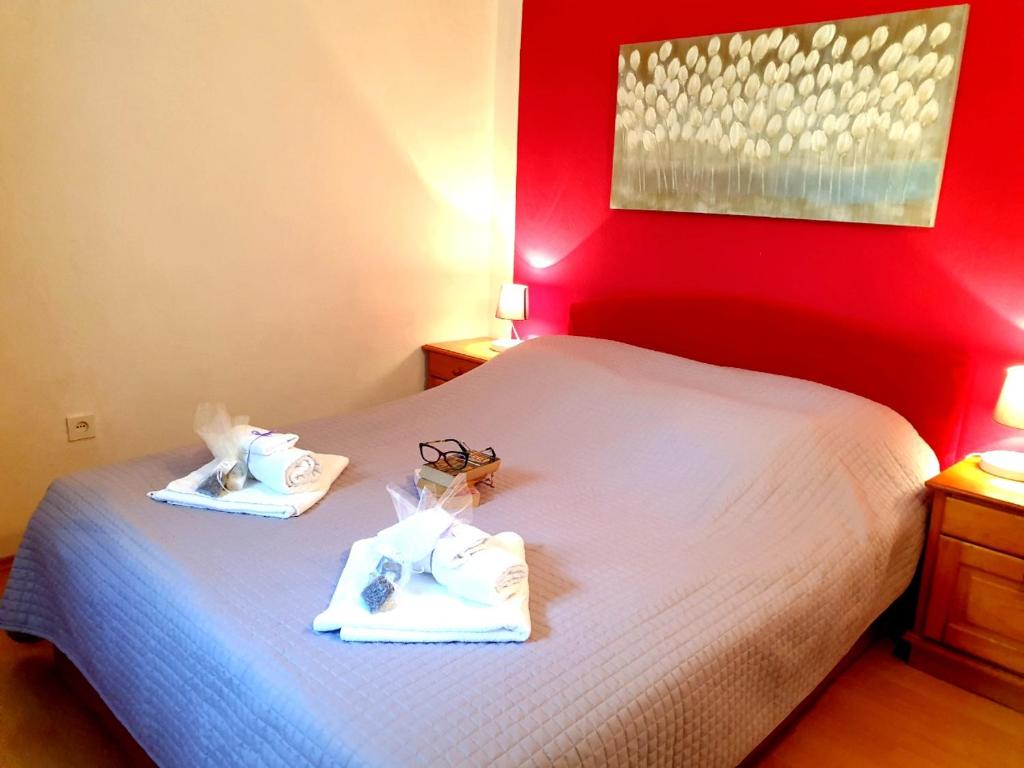 1 dormitorio con cama blanca y pared roja en Martina, en Supetar