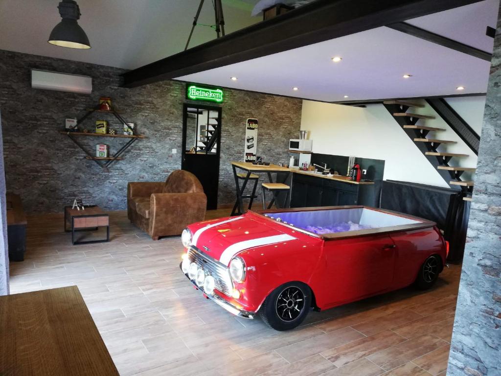 a red car parked in a room with a bar at Le garage de Sophie in Aiguebelette-le-Lac