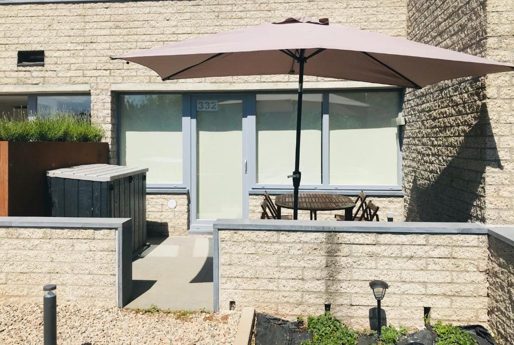 une terrasse avec une table et un parasol dans l'établissement Terrasses de Malmedy Studio 332, à Malmedy
