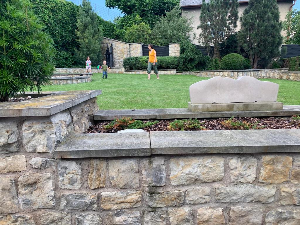 a stone retaining wall with a statue in a park at Antik Hotel Sofia in Litomyšl