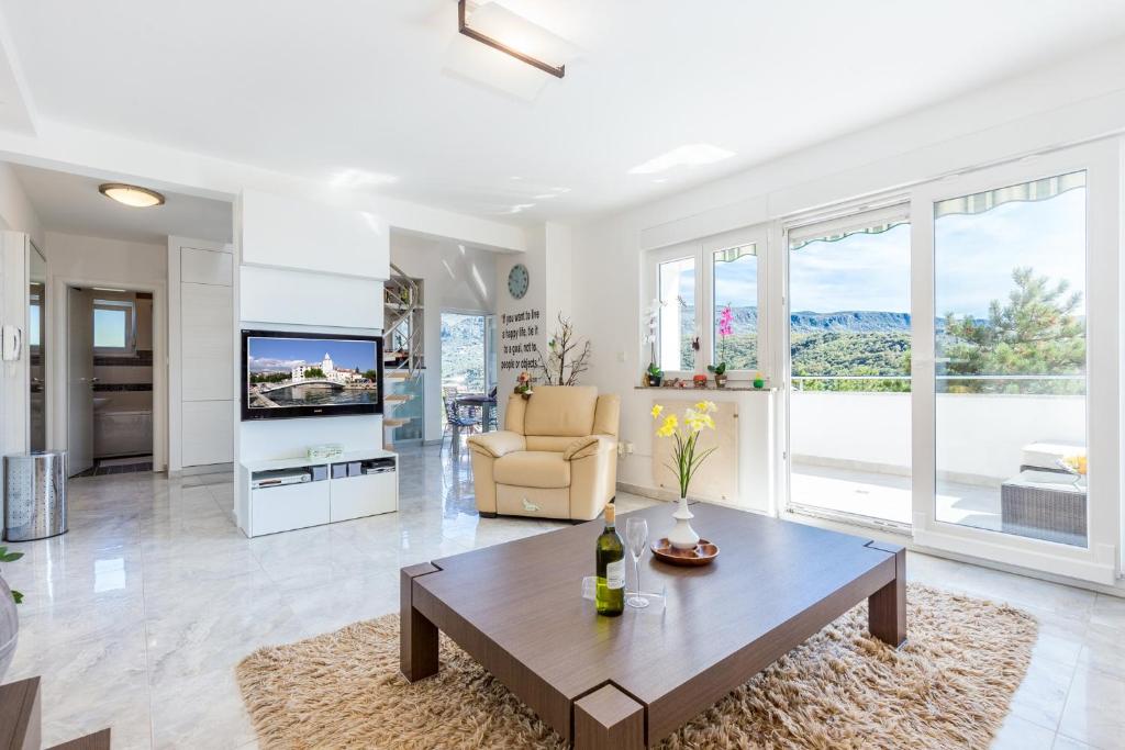 un soggiorno con un tavolo e una TV di Apartman Aqua-Juric a Crikvenica