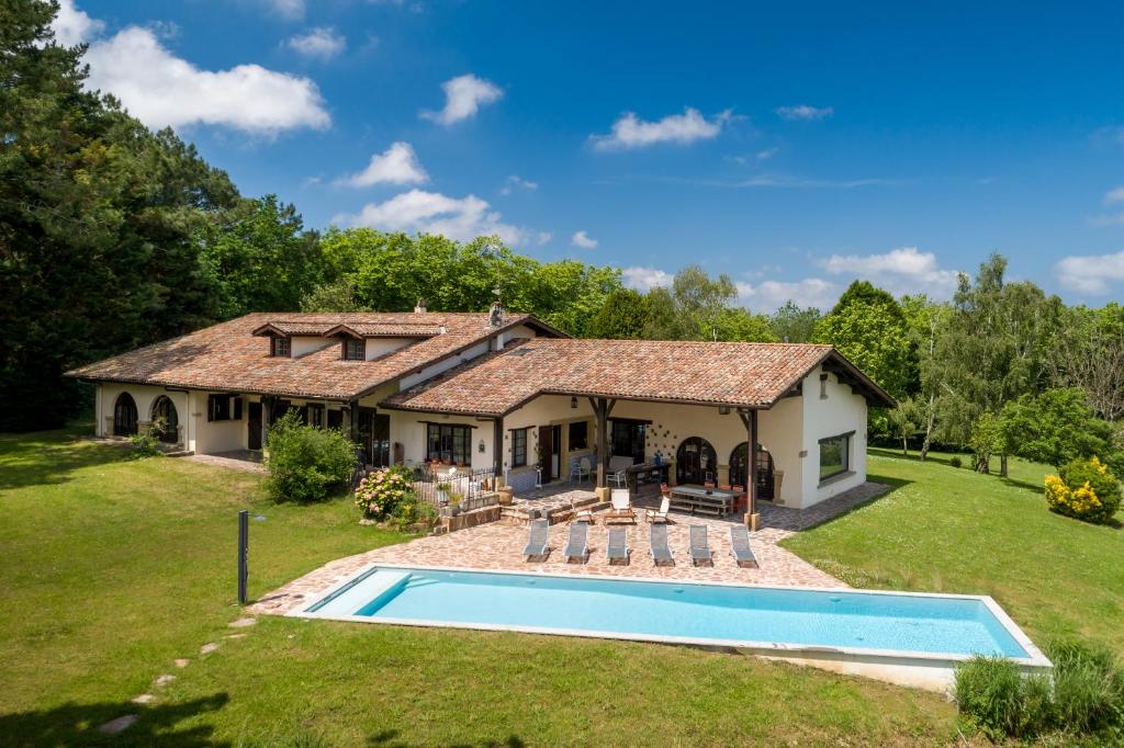 un domaine avec une piscine devant une maison dans l'établissement Etche Churria, à Urrugne