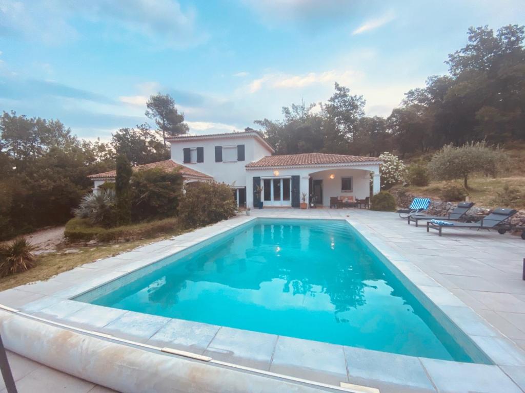 uma piscina em frente a uma casa em la lavande bleue em Le Luc