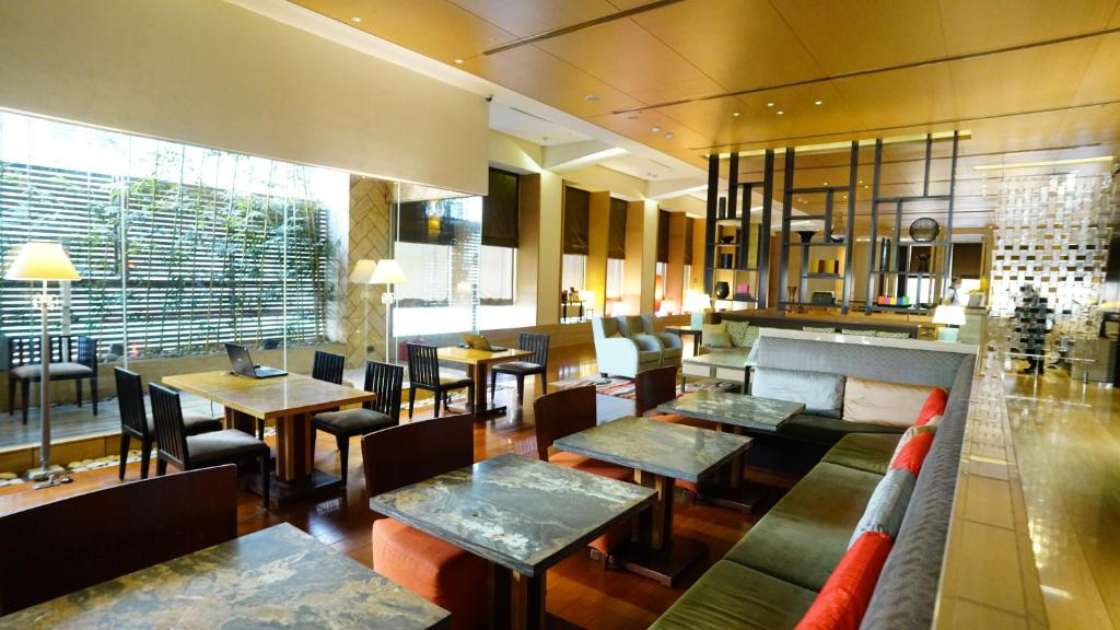 a restaurant with tables and chairs and a couch at City Suites-Taipei Nanxi in Taipei