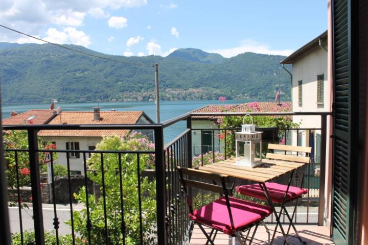 a balcony with a table and chairs and a view of the water at In centro Ca' Leandro Vista lago in Lierna