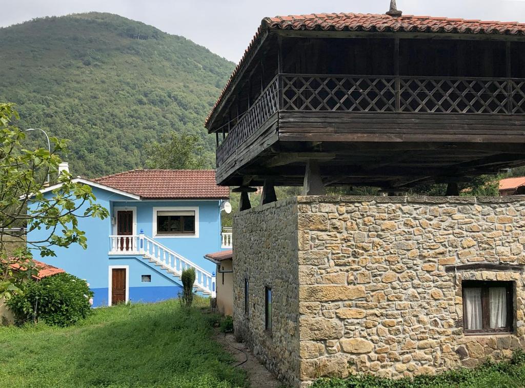 a blue building with a balcony on top of a stone wall at Casa Entremolin in Belmonte de Miranda