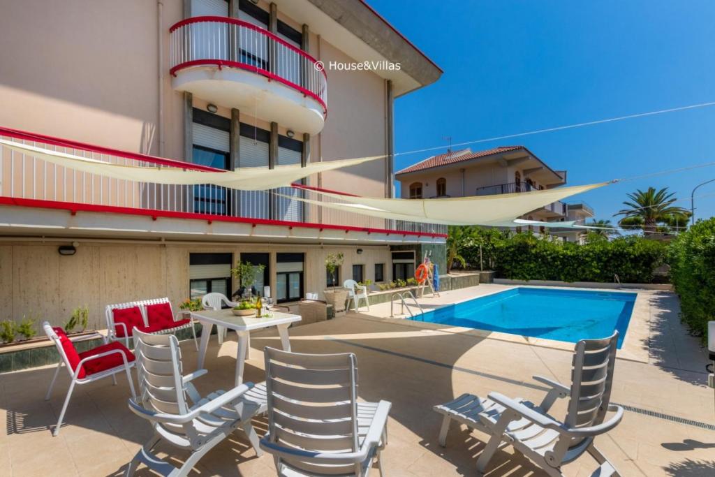 a patio with chairs and a table and a pool at Eden Charming House in Avola