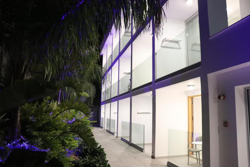 uma vista exterior de um edifício com iluminação roxa em JOY Hotel Apts em Agia Napa