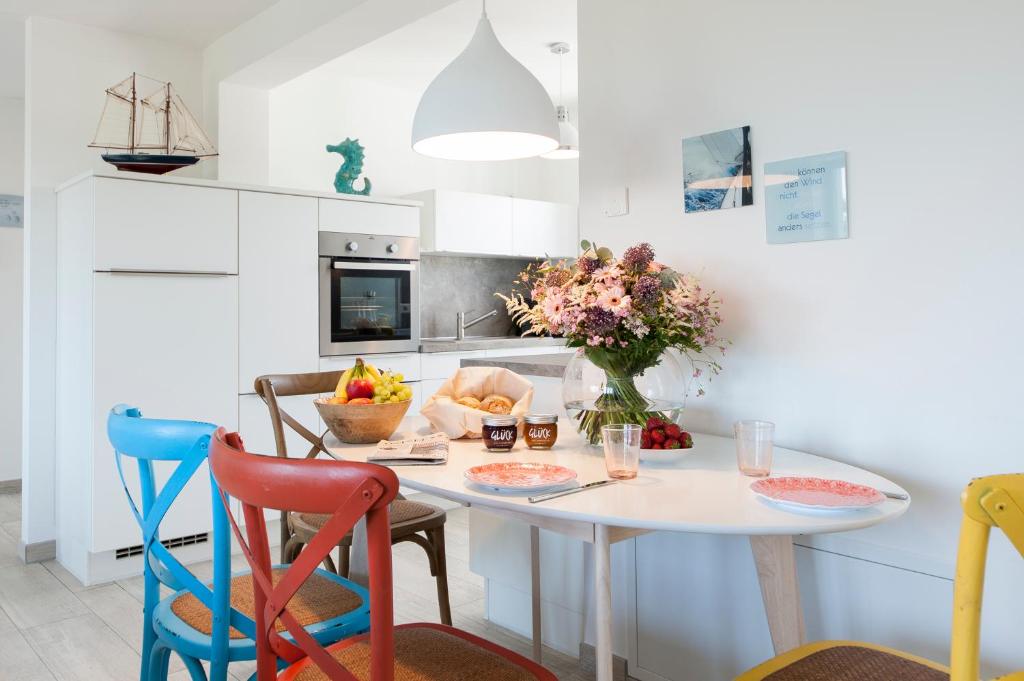 una cocina con una mesa con un jarrón de flores en Haus Verando - Apartment Meeresrauschen II, en Binz