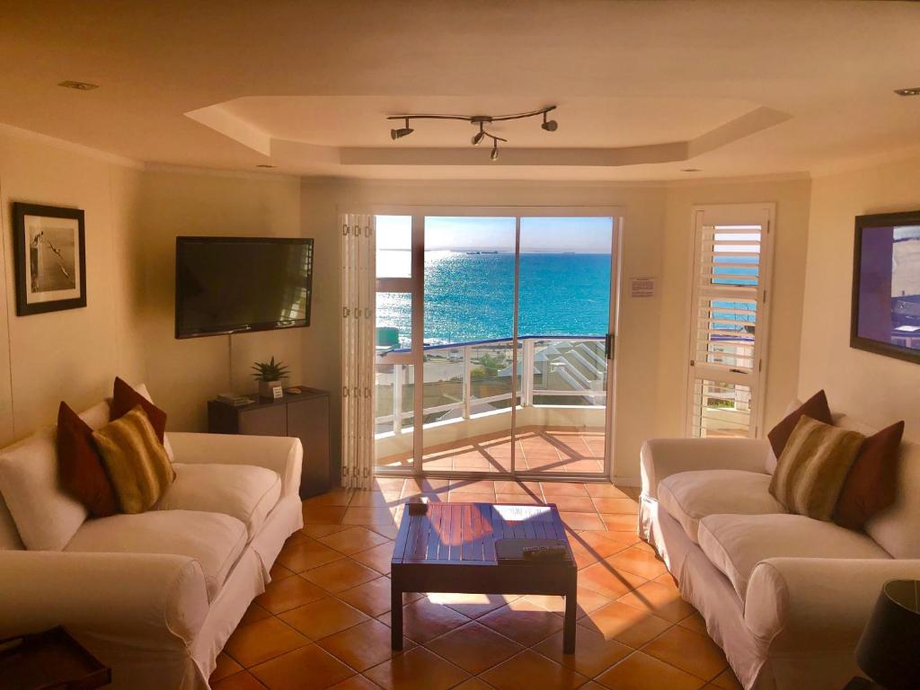 un soggiorno con divani e vista sull'oceano di Brookes Hill Executive Apartment a Port Elizabeth
