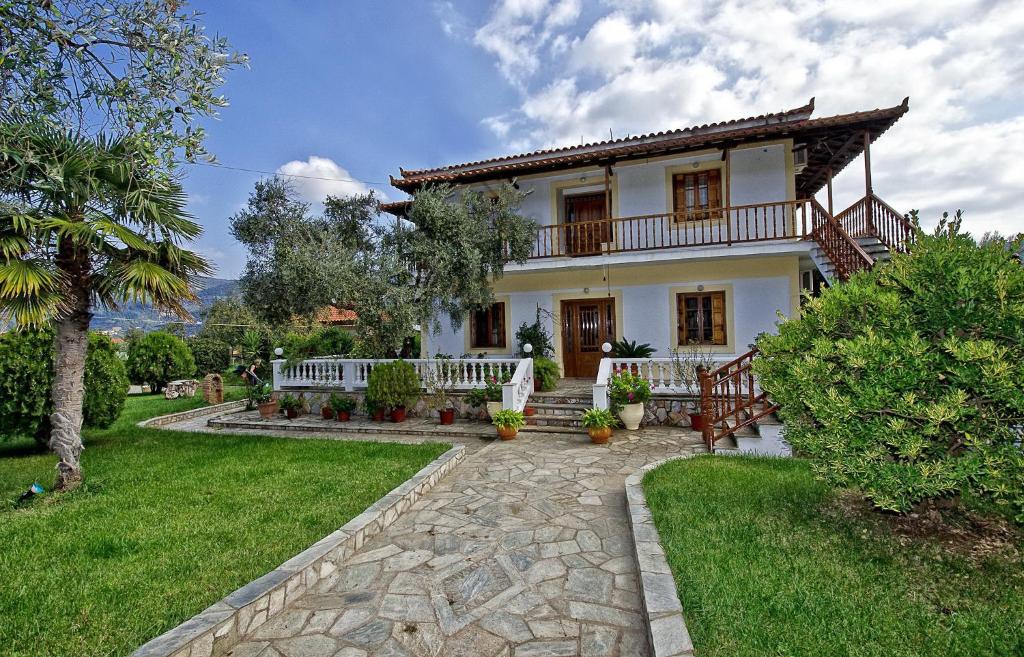 a white house with a porch and a yard at Panagou Studios in Skopelos Town