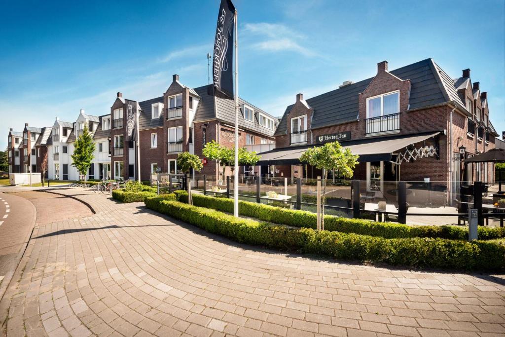 un bâtiment avec un panneau au milieu d'une rue dans l'établissement Grenshotel de Jonckheer, à Ossendrecht