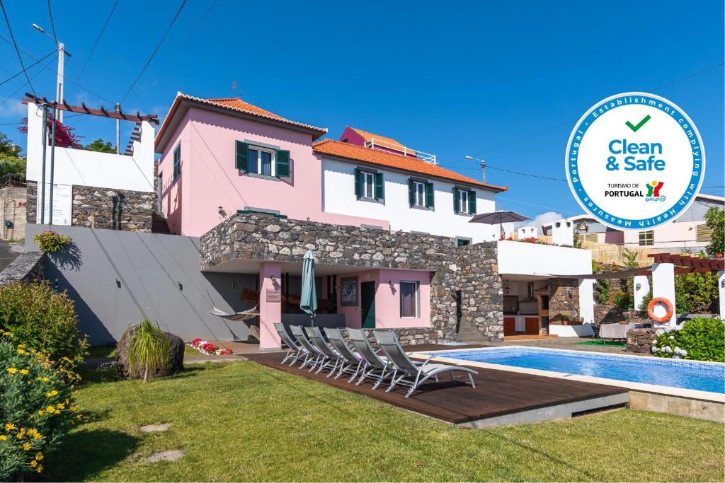 a villa with a swimming pool and a house at OurMadeira - Casa das Orquídeas, sunny location in Calheta