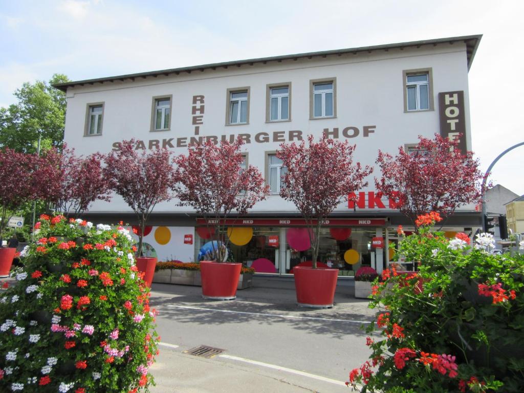 un grand bâtiment blanc avec des fleurs devant lui dans l'établissement Rheinhotel Starkenburger Hof, à Bingen am Rhein