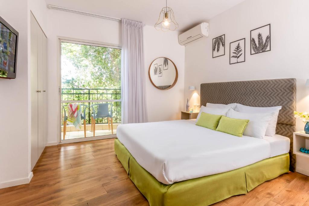 Un dormitorio con una gran cama blanca y una ventana en Travel Hotel Eilon, en Elon