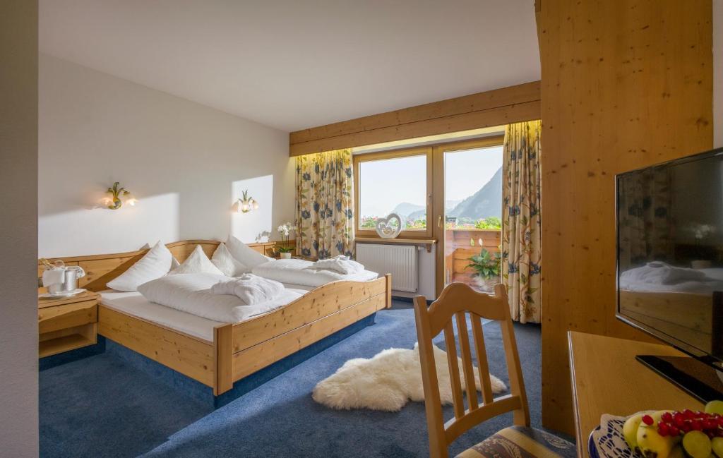 a bedroom with a bed and a large window at Hotel Cafe-Zillertal in Strass im Zillertal